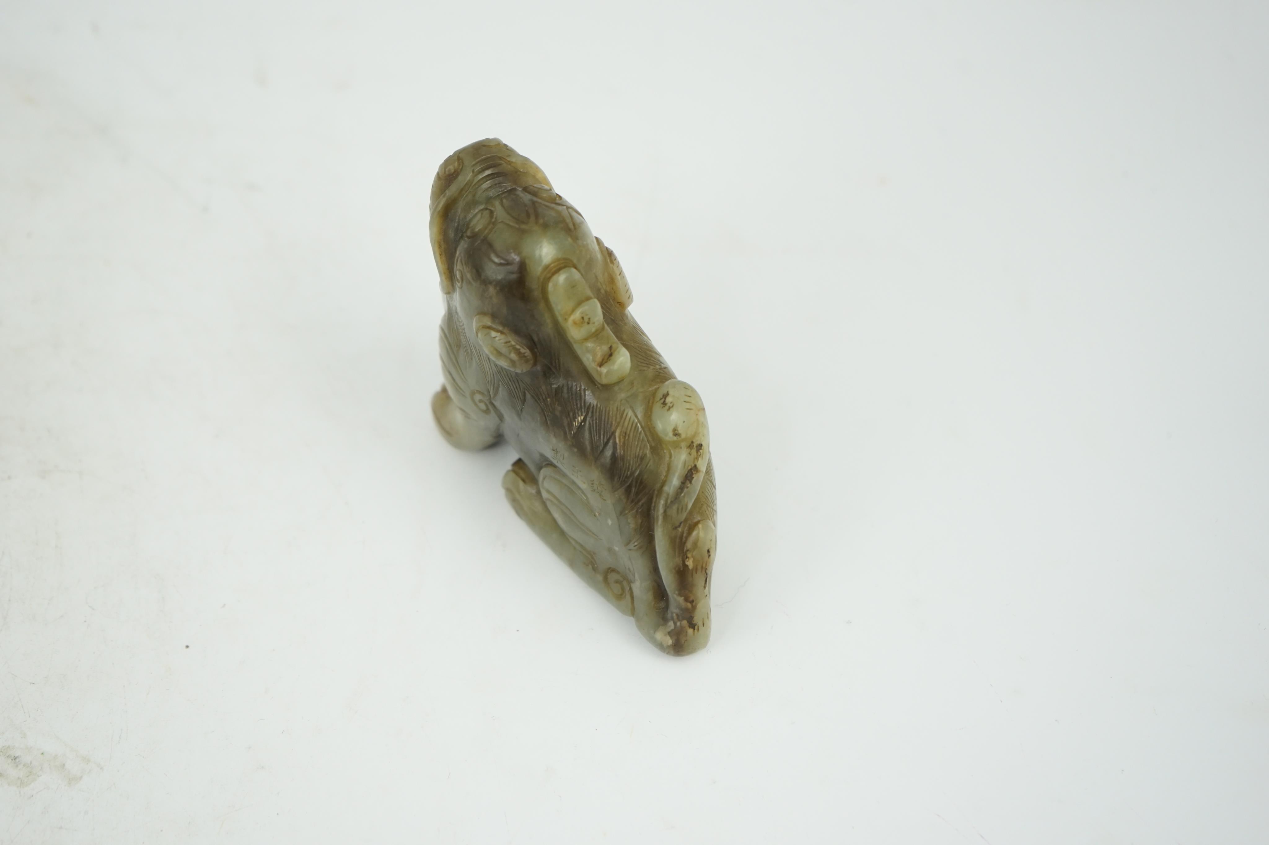 A Chinese pale grey green and black jade figure of a seated Mythical beast, Qing dynasty